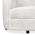 Poltrona moderna in bouclé con braccioli curvi, seduta a rene e gambe rotonde in legno