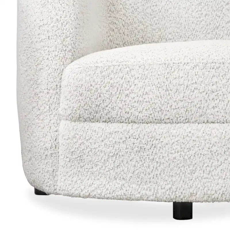 Poltrona moderna in bouclé con braccioli curvi, seduta a rene e gambe rotonde in legno