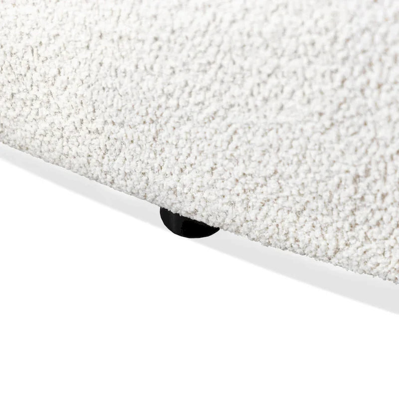 Poltrona moderna in bouclé con braccioli curvi, seduta a rene e gambe rotonde in legno