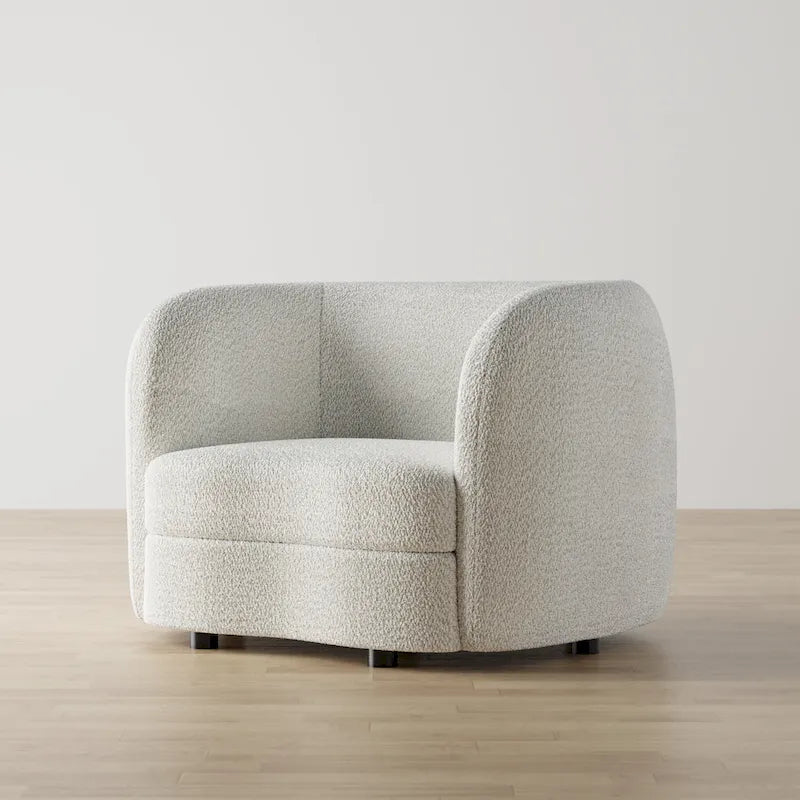 Poltrona moderna in bouclé con braccioli curvi, seduta a rene e gambe rotonde in legno