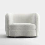 Poltrona moderna in bouclé con braccioli curvi, seduta a rene e gambe rotonde in legno