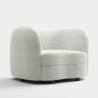 Poltrona moderna in bouclé con braccioli curvi, seduta a rene e gambe rotonde in legno